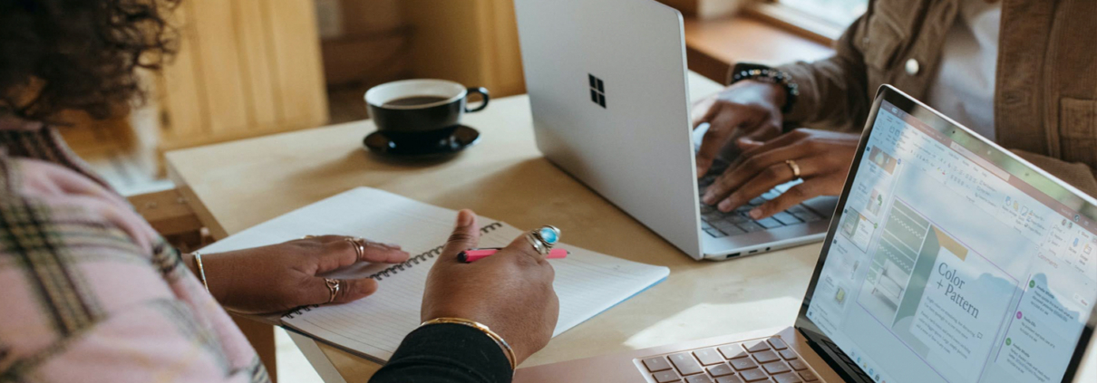 Moça sentada com bloco de papel e caneta sobre a mesa